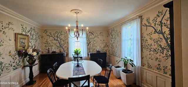 dining space with hardwood / wood-style floors, ornamental molding, and a chandelier