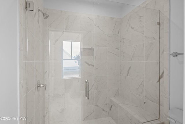 bathroom featuring toilet and a shower with shower door