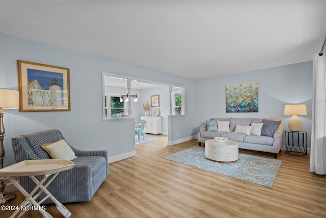 living room with light wood-type flooring and a notable chandelier