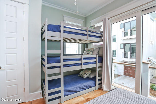 bedroom with ornamental molding and light hardwood / wood-style floors