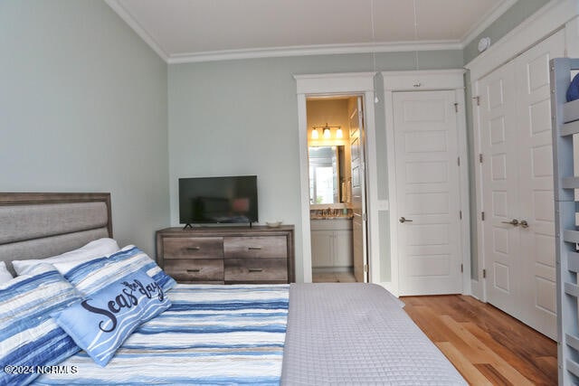 bedroom with crown molding, connected bathroom, and light wood-type flooring