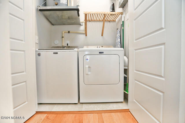 laundry area featuring washer and dryer and light hardwood / wood-style flooring