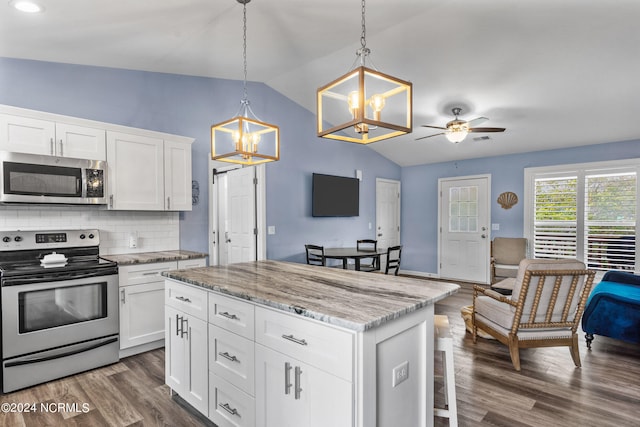 kitchen featuring a center island, ceiling fan with notable chandelier, dark hardwood / wood-style floors, stainless steel appliances, and lofted ceiling