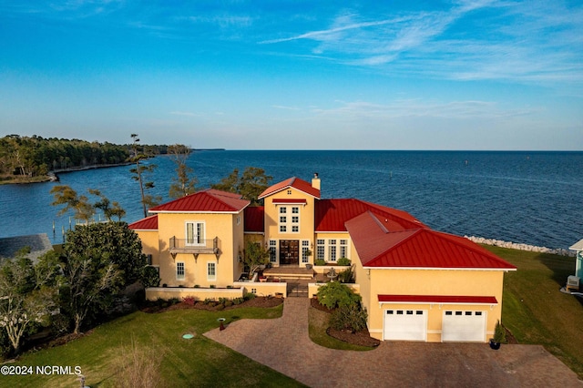 view of front of property featuring a water view, a front yard, and a garage