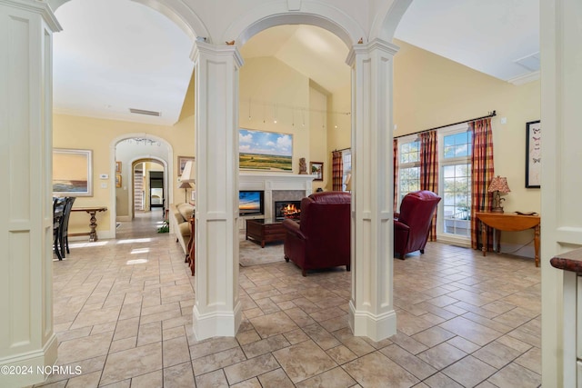 hall featuring ornate columns and light tile flooring