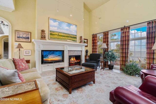 living room featuring a tile fireplace and a high ceiling