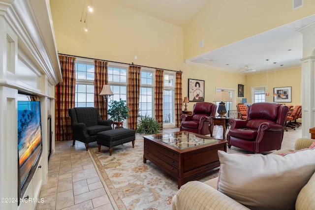 living room featuring light tile floors, a towering ceiling, and a wealth of natural light