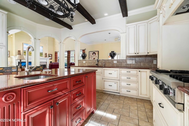 kitchen with beamed ceiling, tasteful backsplash, light tile floors, and sink