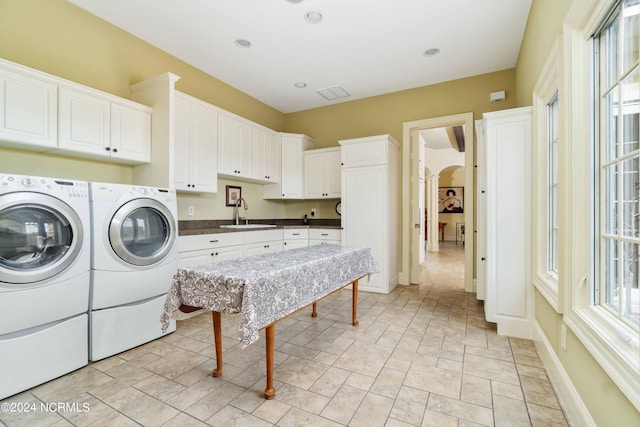 washroom with independent washer and dryer, light tile floors, cabinets, and sink