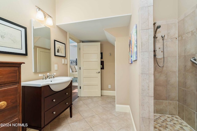 bathroom with tile floors, vanity with extensive cabinet space, and tiled shower