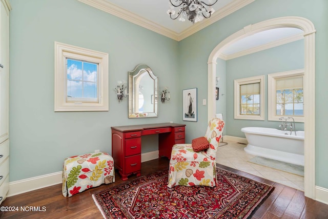 living area with a wealth of natural light, a notable chandelier, hardwood / wood-style flooring, and crown molding