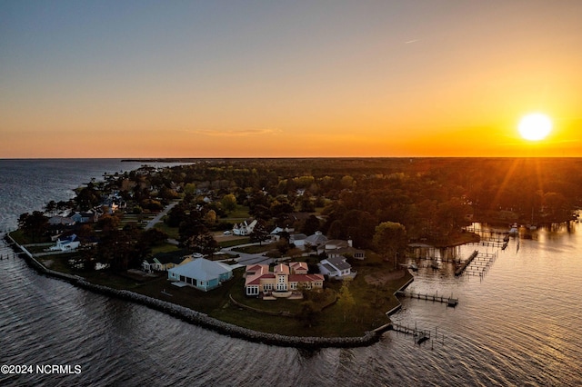 aerial view at dusk featuring a water view