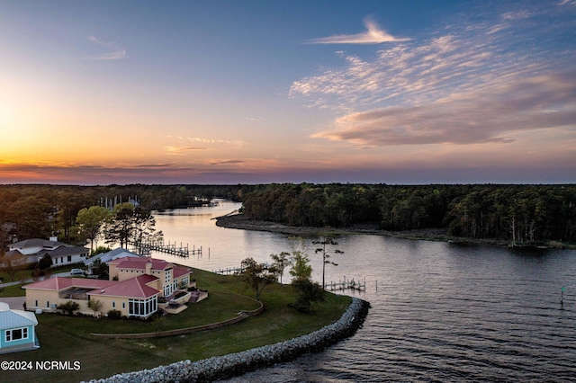 aerial view at dusk featuring a water view