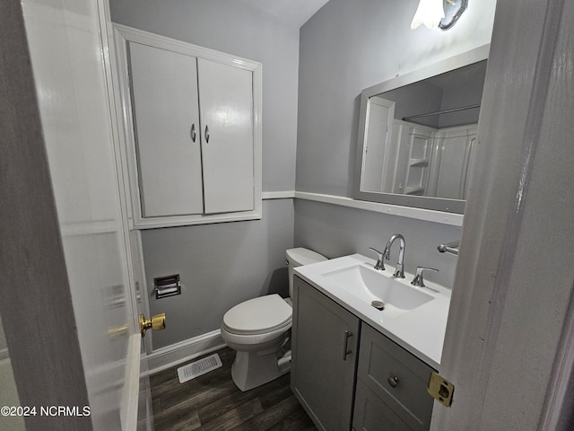 bathroom with vanity, toilet, and hardwood / wood-style floors