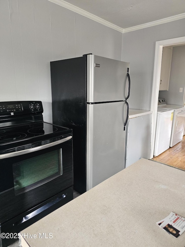 kitchen with electric range, hardwood / wood-style flooring, stainless steel fridge, white cabinets, and crown molding