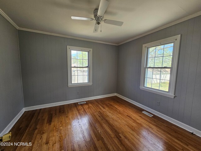 spare room with hardwood / wood-style flooring, ceiling fan, and crown molding