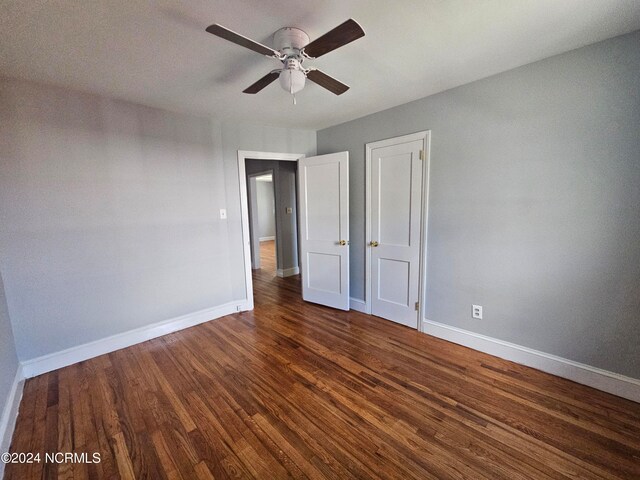 unfurnished bedroom with ceiling fan and dark hardwood / wood-style flooring