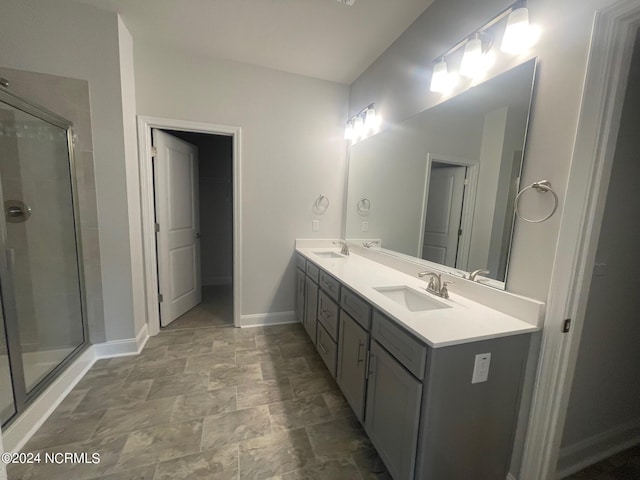 bathroom with tile floors, a shower with door, and dual bowl vanity