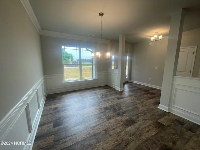 unfurnished dining area with ornamental molding, dark hardwood / wood-style flooring, and an inviting chandelier