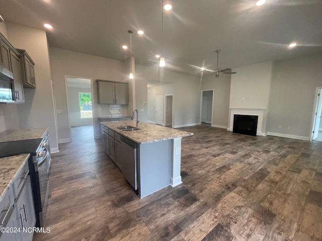 kitchen featuring dark hardwood / wood-style flooring, a center island with sink, ceiling fan, sink, and appliances with stainless steel finishes