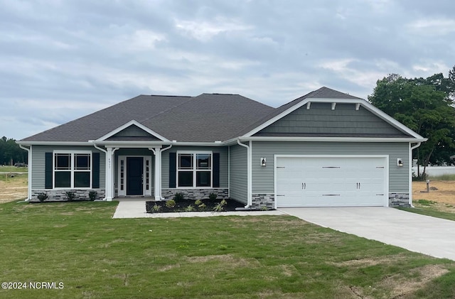 craftsman-style home featuring a garage and a front lawn