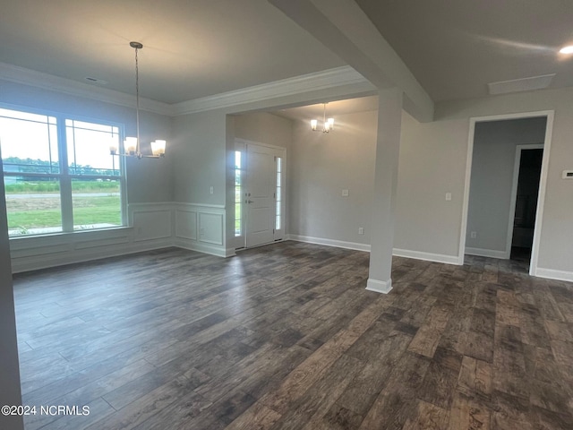 unfurnished room featuring dark wood-type flooring, a chandelier, and ornamental molding