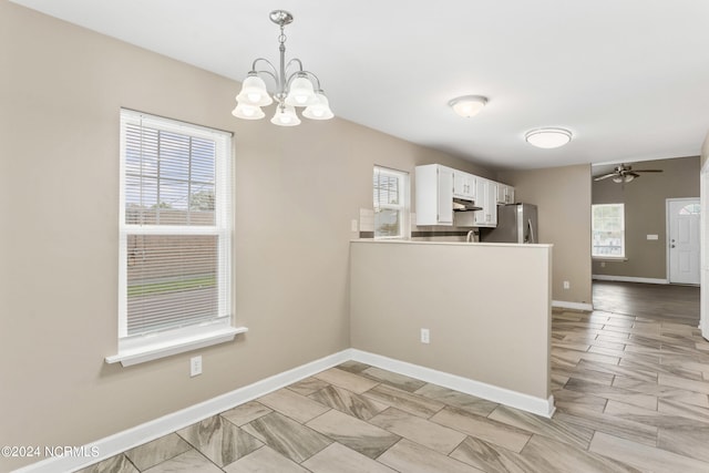 kitchen featuring white cabinets, hanging light fixtures, plenty of natural light, and light tile floors