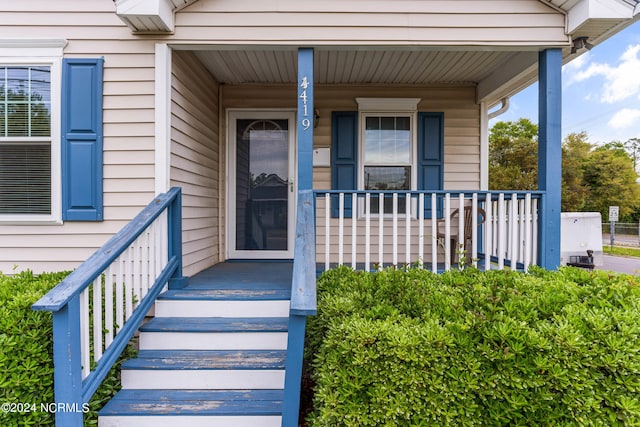 view of exterior entry featuring covered porch