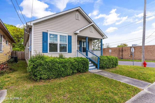 bungalow-style home featuring a porch, central AC, and a front lawn