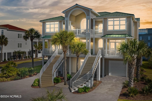 raised beach house with a porch and a garage