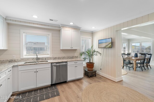 kitchen featuring ornamental molding, white cabinetry, sink, stainless steel dishwasher, and light hardwood / wood-style floors