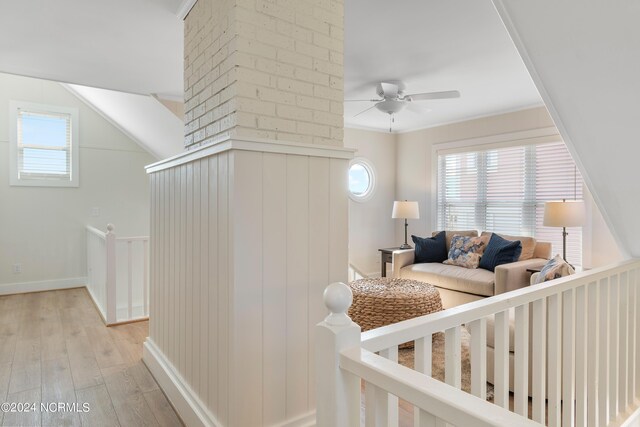 living room with light hardwood / wood-style flooring, ceiling fan, ornamental molding, and a healthy amount of sunlight