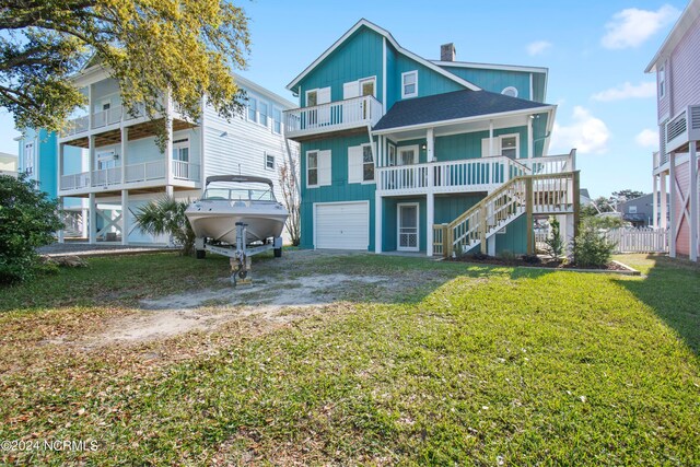 rear view of house featuring a garage, a lawn, and a balcony