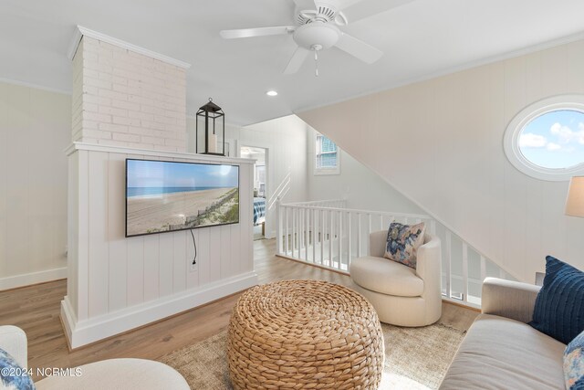 living room featuring lofted ceiling, ceiling fan, ornamental molding, and light hardwood / wood-style flooring