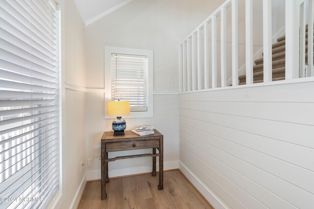 stairs featuring lofted ceiling, hardwood / wood-style floors, and plenty of natural light