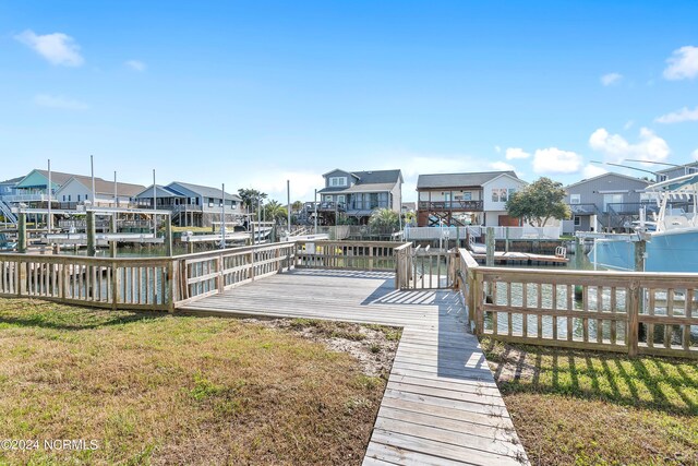 view of dock featuring a yard and a deck with water view