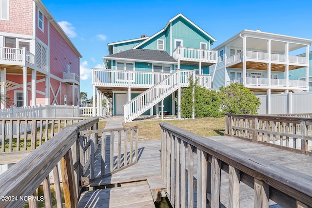 rear view of property with a wooden deck and a balcony