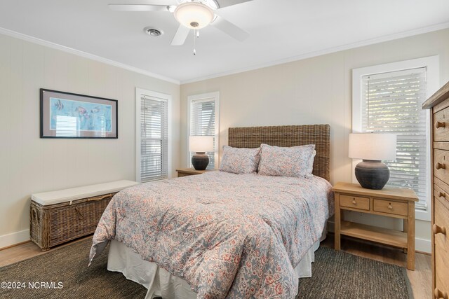 bedroom with ornamental molding, dark wood-type flooring, and ceiling fan