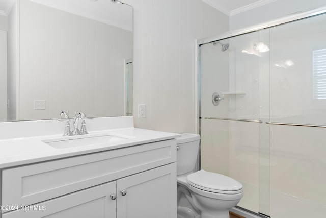 bathroom with vanity, toilet, ornamental molding, and walk in shower