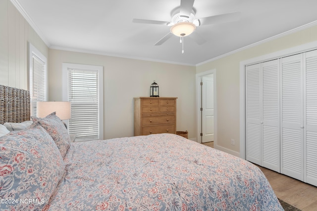 bedroom featuring a ceiling fan, a closet, ornamental molding, and wood finished floors