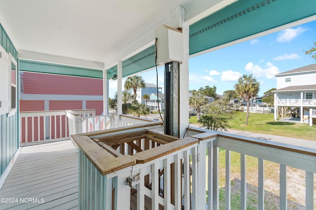 wooden terrace featuring a yard and covered porch