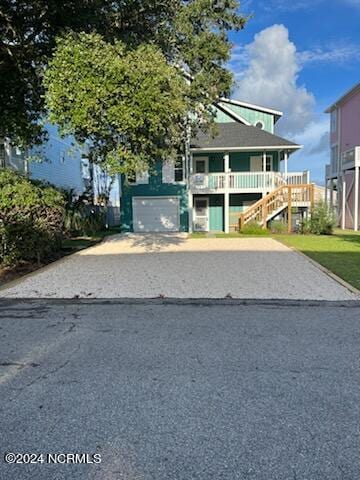 view of front of house featuring driveway, a garage, and stairway