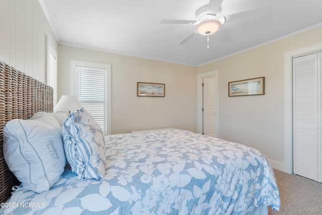 carpeted bedroom with baseboards, ceiling fan, ornamental molding, and a closet