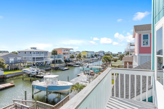 balcony featuring a water view, a boat dock, and boat lift