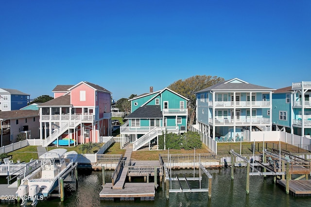 dock area with a water view, boat lift, a residential view, and stairway