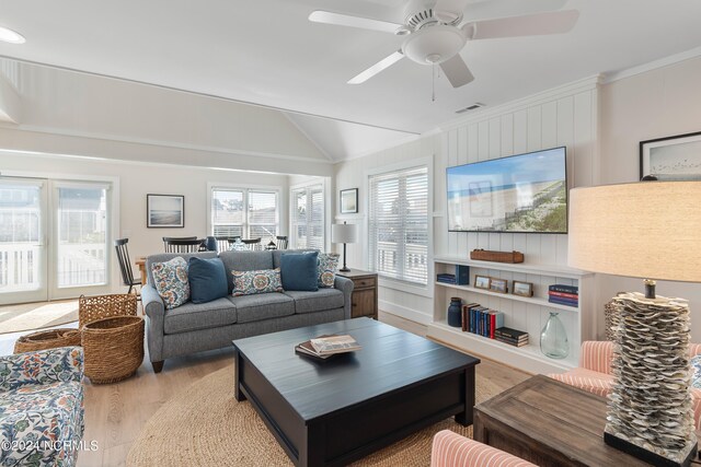 living room with lofted ceiling, ceiling fan, light wood-type flooring, and ornamental molding