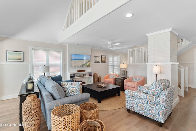 living area with ceiling fan, ornamental molding, and wood finished floors