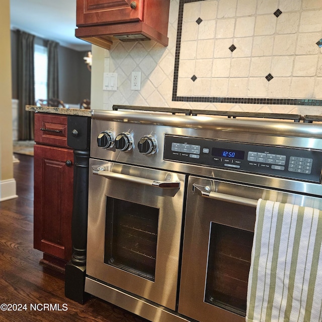 kitchen with dark hardwood / wood-style floors, decorative backsplash, and high end range