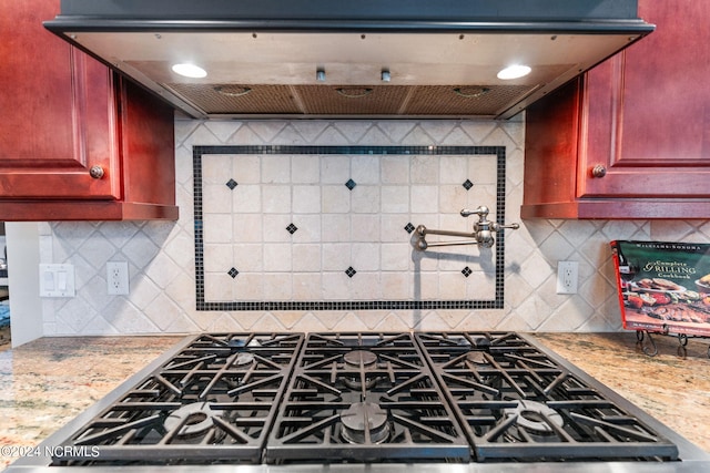 kitchen featuring ventilation hood, decorative backsplash, stainless steel range oven, and light stone countertops