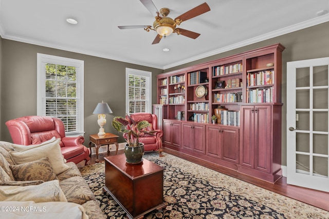 living area featuring ceiling fan, hardwood / wood-style floors, and crown molding